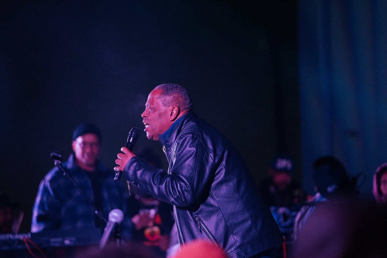 Lawrence Dopson singing into a microphone on stage